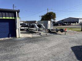 Outdoor vehicle storage in Marco Island, featuring various trailers and jet skis