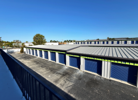 An upper level view from a balcony of walk-up units looking down on an aisle of drive-up storage units in Marco Island, FL