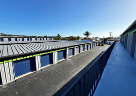 An upper level view from a balcony of walk-up units looking down on an aisle of drive-up storage units in Marco Island, FL
