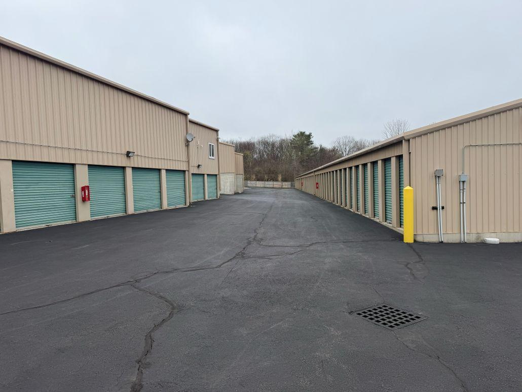 Wide drive aisle with outdoor drive-up storage units at Storage Star self-storage in Dracut, MA